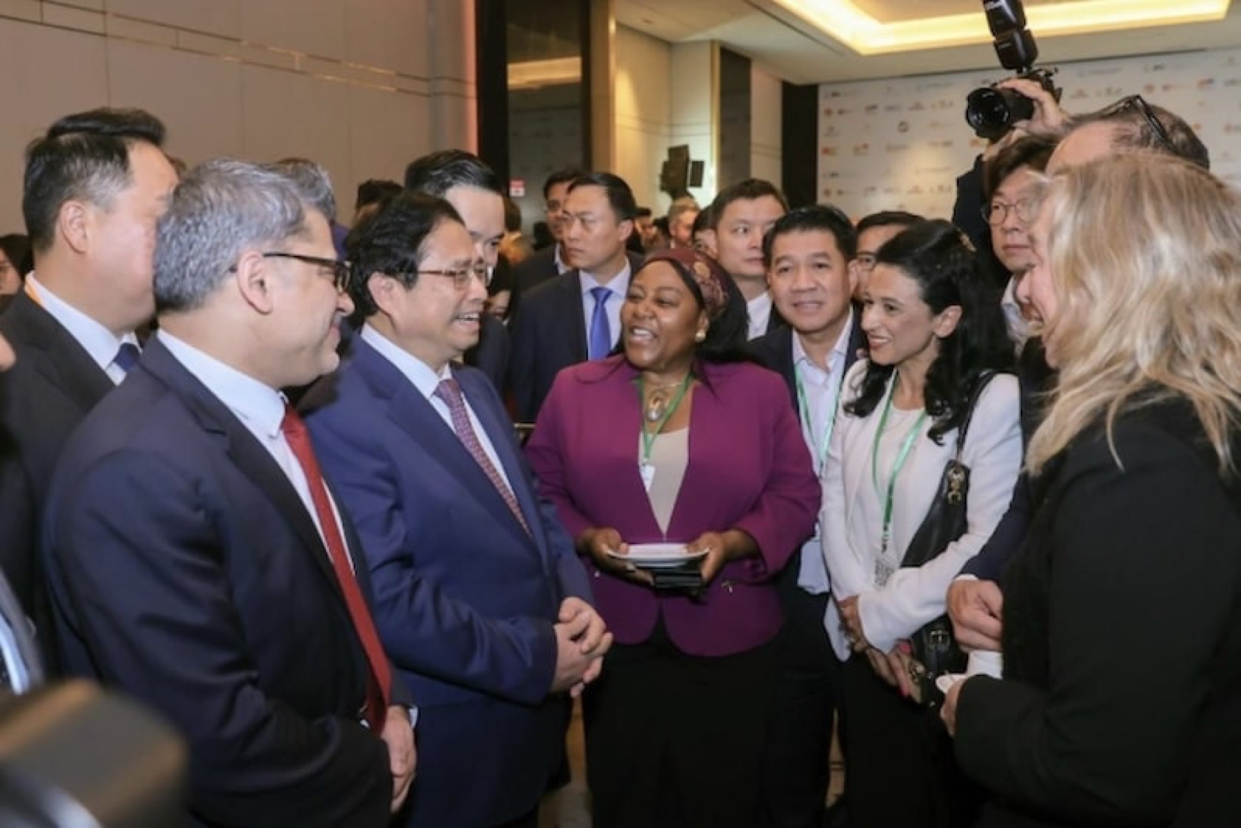 A delegation of officials and business representatives talking before cameras